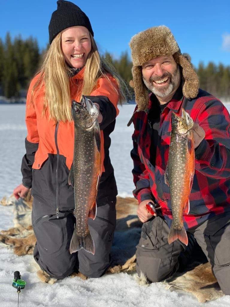 Frau und Mann zeigen Ihre gefangenen Fische beim Eisangeln
