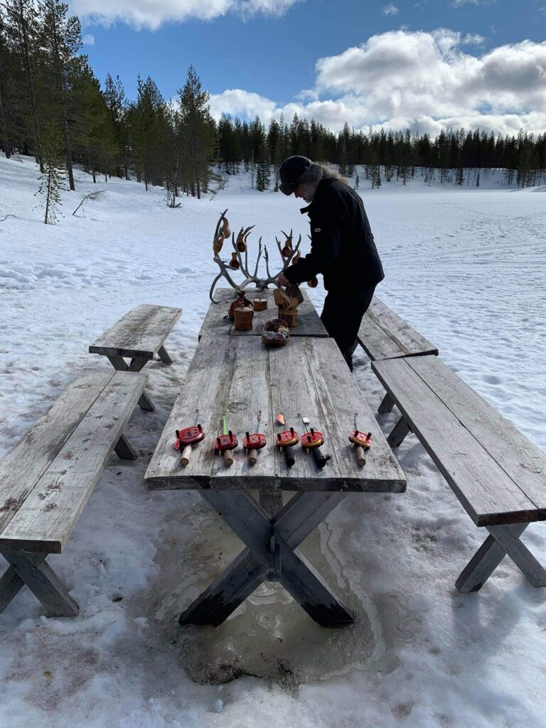 Großer Holztisch mit Angeln für das Eisangeln vorbereitet.